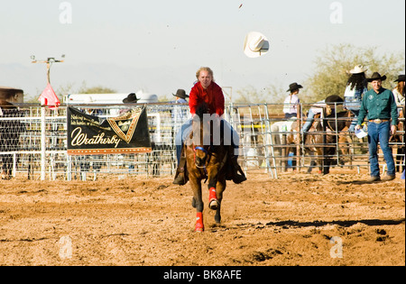 a cowgirl competes in the barrel racing event at a rodeo Stock Photo