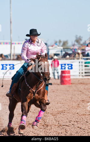 a cowgirl competes in the barrel racing event at a rodeo Stock Photo