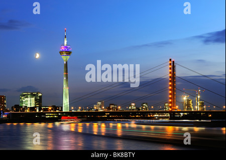 View from the bank of the Rhine River across the Rhine to the skyline of Duesseldorf and the Rheinturm Tower and Rheinkniebruec Stock Photo