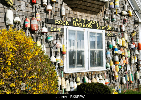 Lobster buoys hanging on the side of a  Cape Cod shingled building Captain Cass Rock Harbor Seafood, Orleans, Massachusetts USA Stock Photo