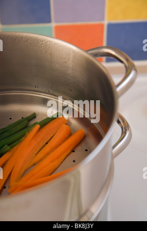 Cooking fresh vegetables in a steamer Stock Photo
