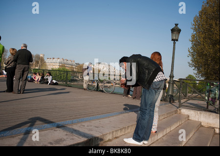 Paris, France, Couple Enjoying Spring Weather on Seine River, Man Taking Photos on 'Pont des Arts' Stock Photo
