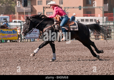 Cowgirl riding fast during barrel racing, Cochrane Rodeo, Cochrane, Alberta, Canada Stock Photo