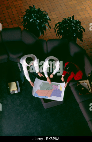 Overhead view of business people meeting in the upscale contemporary lobby of a corporate office building. Stock Photo
