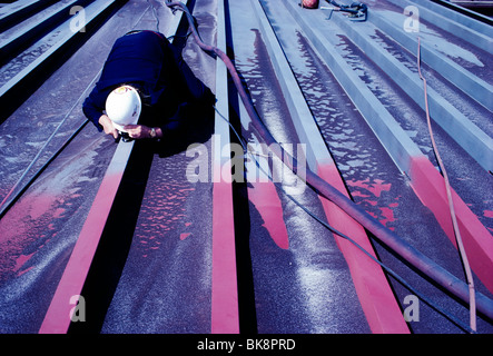 Engineer inspecting the metal finish on a barge that has just been sand blasted in preparation for painting Stock Photo