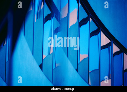 Abstract view of a modern corporate office building including reflections in the windows of the sunset sky Stock Photo