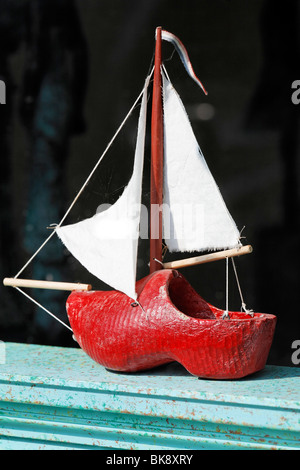 Small sailboat in the display window, made of Dutch wooden clogs, lettering 'Klompen', Dutch for 'clogs', handicrafted, De Rijp Stock Photo