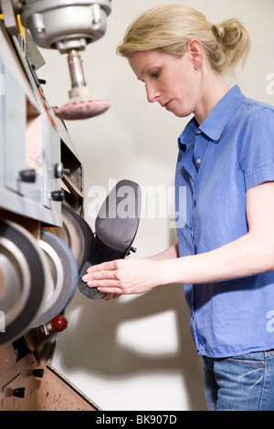 Shoemaker grinding the sole of the shoe Stock Photo