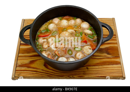 A hearty stew being prepared in a cast-iron pot, isolated on a white background. Stock Photo