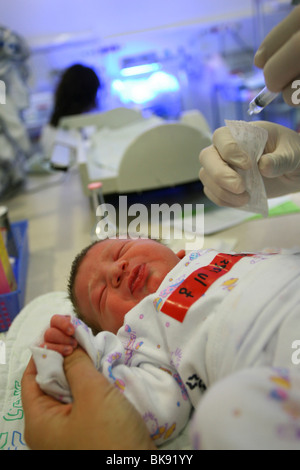 A baby girl is getting her first vaccination at the hospital, few hours after birth. Stock Photo