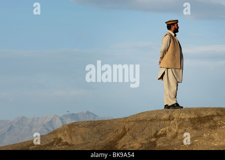 Man in traditional Afghan clothes buys pheasant on the birds market in ...