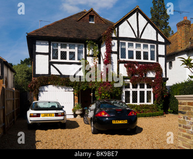 Mock Tudor 1930's house with cars on the drive, and garage, in Esher, Surrey. UK. Stock Photo