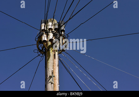 old style telephone pole with chandelier against a deep blue sky uk Stock Photo