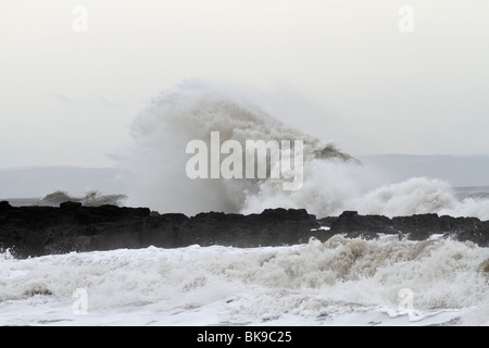 Atlantic breakers on the beach at Porthcawl running alongside the Esplanade. Waves on the rocks Stock Photo