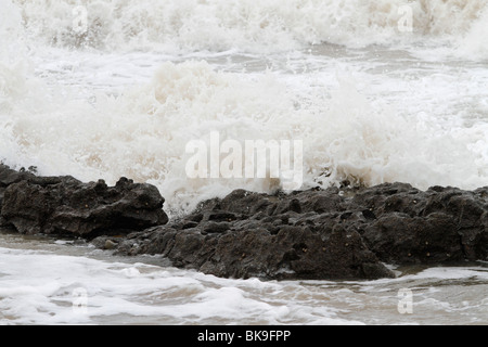 Atlantic breakers on the beach at Porthcawl running alongside the Esplanade. Waves on the rocks Stock Photo