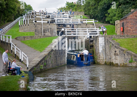 A barge narrowboat navigating The Five Rise Locks  at Bingley near Bradford West Yorkshire UK Stock Photo