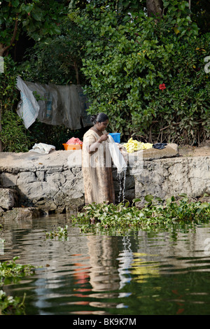 Woman doing laundry in Backwaters of Kerala, India. Stock Photo