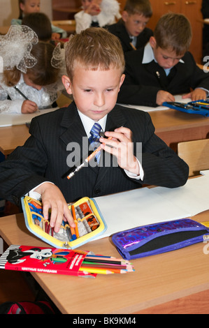 Russian boy Caucasian student are sitting on the lesson in classroom in school at first September. Stock Photo