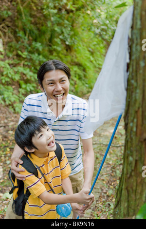 Father and Son Catching Insects Stock Photo