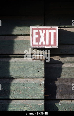 red exit sign notice old wooden door on property Stock Photo