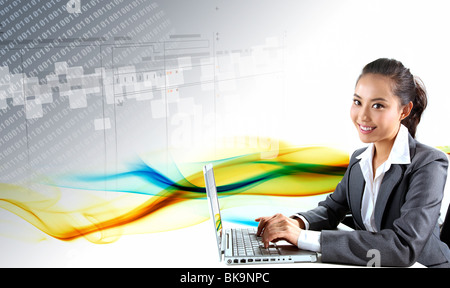 Businesswoman working on laptop,digital composite Stock Photo
