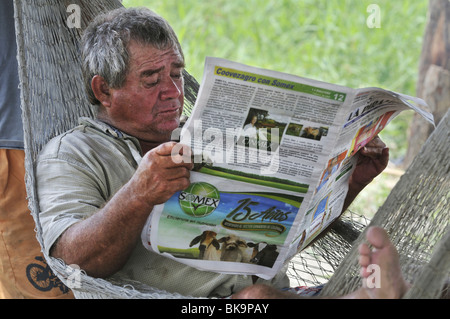 Man reading a newspaper in a hammock, La Dorada, Caldas, Colombia, South America Stock Photo