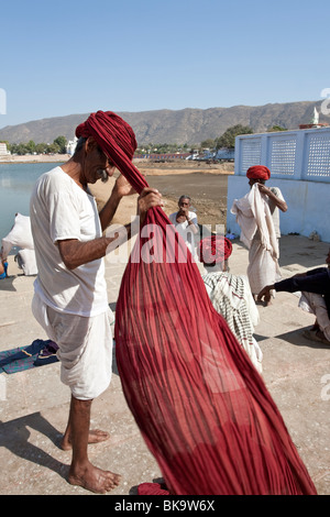 Indian man putting on his turban. Pushkar. Rajasthan. India Stock Photo