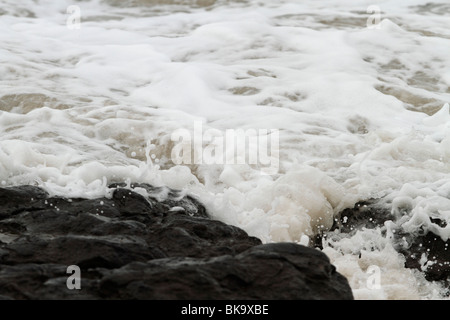 Atlantic breakers on the beach at Porthcawl running alongside the Esplanade. Waves on the rocks Stock Photo