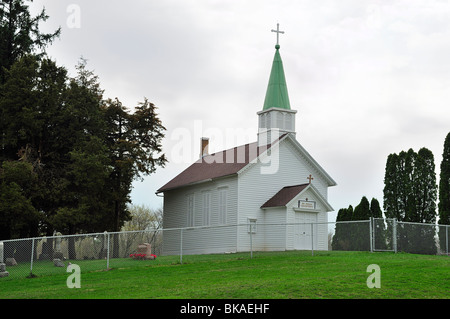 Tiny Catholic church and cemetery on hillside in small town USA Stock Photo