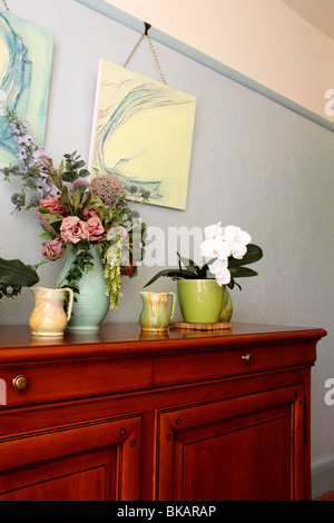 Cherry wood sideboard with art deco ceramics, phalenopsis and original art work Stock Photo