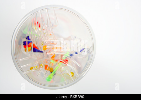 high viw of transparent plastic glass with colorful sticks and forks Stock Photo