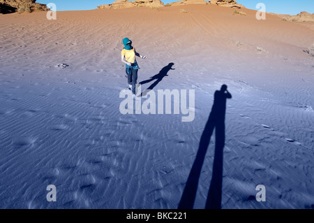 A Woman Running Down a Red Sand Dune Stock Photo