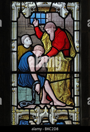 A stained glass window depicting once of the Corporal Acts of Mercy, Visiting the Prisoners, Stock Photo