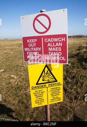 Warning sign for military firing range MOD Castlemartin range on coastal footpath Pembrokeshire Wales UK Stock Photo