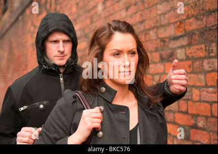 Male stalking lone female to steal handbag. Posed by Models. FULLY MODEL RELEASED Stock Photo