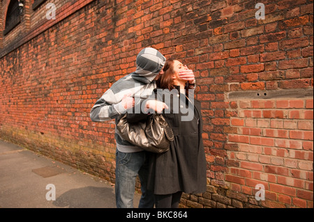 Male stalking lone female to steal handbag. Posed by Models. FULLY MODEL RELEASED Stock Photo