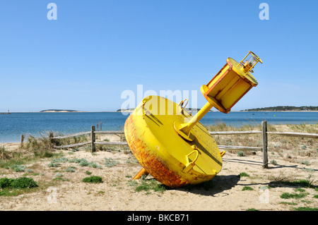 Yellow channel marker on beach at Wellfleet Harbor, Cape Cod Stock Photo