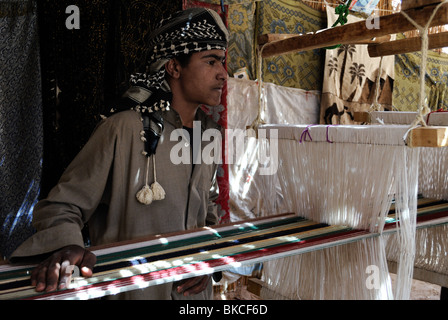 Young Bedouin man weaving inside tent Stock Photo