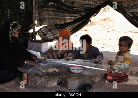 Bedouin women and children making bread inside tent Stock Photo