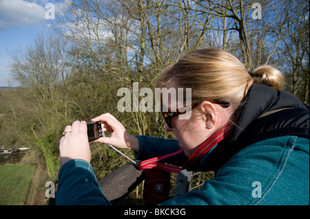 Woman using a compact digital camera to take a photograph. Stock Photo