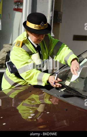 A woman traffic warden issuing a parking ticket for a car that already has two tickets issued already, Aberystwyth Wales UK Stock Photo