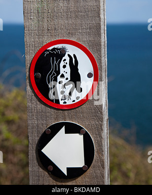 Danger cliff edge symbol on Pembrokeshire coast path Wales UK Stock Photo