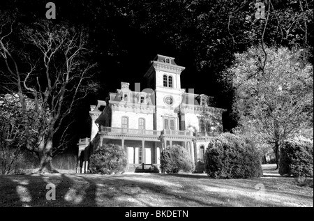 A glowing Victorian Antebellum house on a scary dark day. What danger lurks within? Photo by Darrell Young. Stock Photo