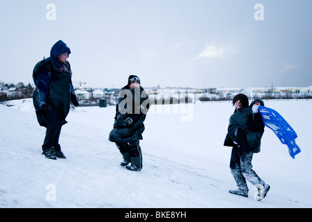 Three boys playing in the snow. Hafnarfjordur, Greater Reykjavik Area, Iceland Stock Photo