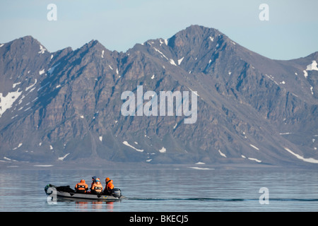 Norway, Svalbard, Norwegian Polar Institute researchers cruising in Zodiac on Prins Karls Forland on summer morning Stock Photo