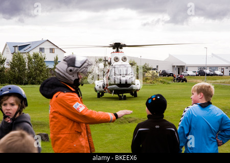 People gather around a helicopter from The Icelandic Coast Guard, Vogar in Vatnsleysustrond, Iceland. Stock Photo