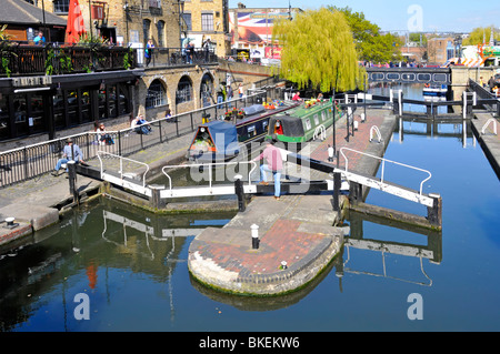 Looking down on lock gates sunny urban landscape & narrowboats in Camden Lock on Regents Canal with weeping willow tree beyond North London England UK Stock Photo