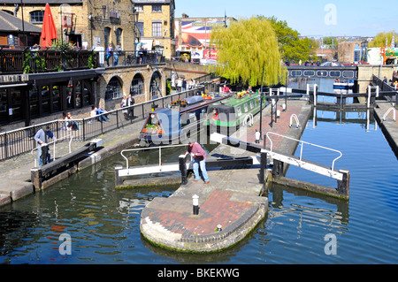 Looking down on lock gates sunny urban landscape & narrowboats in Camden Lock on Regents Canal with weeping willow tree beyond North London England UK Stock Photo