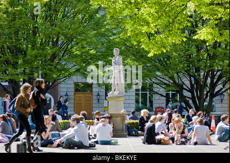 People resting on warm spring day in Golden Square, W1, London, United Kingdom Stock Photo