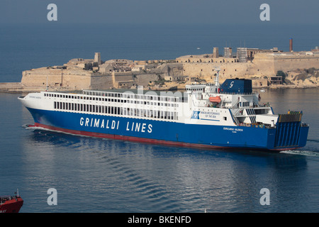 Commercial sea transport. The Grimaldi Lines ro-ro ferry Eurocargo Valencia departing from Malta's Grand Harbour, with Fort Ricasoli in the background Stock Photo